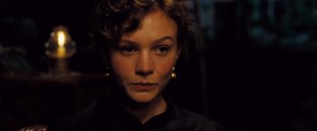 Movie still from “Far from the Madding Crowd” (2015), directed by Thomas Vinterberg – A person with curly hair wearing earrings; Close Up shot, Over the shoulder angle