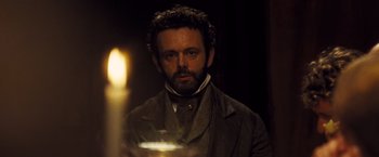 Movie still from “Far from the Madding Crowd” (2015), directed by Thomas Vinterberg – A man with a beard is standing in front of a candle; Close Up shot, Over the shoulder angle