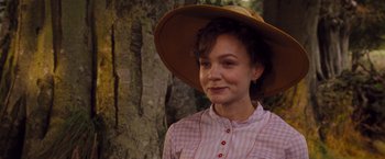 Movie still from “Far from the Madding Crowd” (2015), directed by Thomas Vinterberg – A woman wearing a hat standing in front of a tree; Close Up shot, Over the shoulder angle