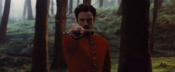 Movie still from “Far from the Madding Crowd” (2015), directed by Thomas Vinterberg – A man in a red and black uniform holding a sword; Medium shot, Over the shoulder angle