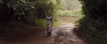 Movie still from “Far from the Madding Crowd” (2015), directed by Thomas Vinterberg – A woman in a gray dress walking down a dirt road; Wide shot, Low angle