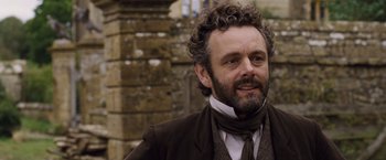 Movie still from “Far from the Madding Crowd” (2015), directed by Thomas Vinterberg – A person wearing a suit and tie; Close Up shot, Over the shoulder angle
