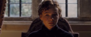 Movie still from “Far from the Madding Crowd” (2015), directed by Thomas Vinterberg – A young person is sitting in a chair looking at the camera; Close Up shot, Over the shoulder angle