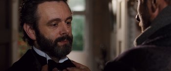 Movie still from “Far from the Madding Crowd” (2015), directed by Thomas Vinterberg – A man with a beard is adjusting a bow tie; Close Up shot, Over the shoulder angle