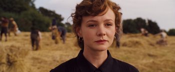 Movie still from “Far from the Madding Crowd” (2015), directed by Thomas Vinterberg – A person with curly hair wearing a black shirt; Close Up shot, Over the shoulder angle