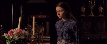 Movie still from “Far from the Madding Crowd” (2015), directed by Thomas Vinterberg – A young girl standing in front of a fire place; Medium shot, Over the shoulder angle