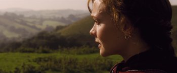 Movie still from “Far from the Madding Crowd” (2015), directed by Thomas Vinterberg – A young girl looking out over a green valley; Close Up shot, Over the shoulder angle