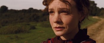 Movie still from “Far from the Madding Crowd” (2015), directed by Thomas Vinterberg – A woman's face in a grassy field; Close Up shot, Low angle