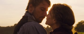 Movie still from “Far from the Madding Crowd” (2015), directed by Thomas Vinterberg – A man and a woman kissing in front of a sunset; Close Up shot, Low angle