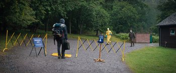 Movie still from “In the Earth” (2021), directed by Ben Wheatley – A man in a yellow raincoat and a woman in a yellow rain suit; Extreme Wide shot, Over the shoulder angle