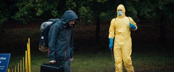 Movie still from “In the Earth” (2021), directed by Ben Wheatley – Two people in yellow suits and blue bags; Medium shot, Low angle