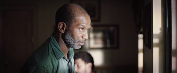 Movie still from “In the Earth” (2021), directed by Ben Wheatley – An older man with a gray beard looking to his left; Close Up shot, Over the shoulder angle