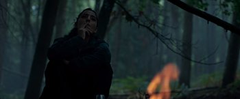 Movie still from “In the Earth” (2021), directed by Ben Wheatley – A man smoking a cigarette in the woods; Medium shot, Low angle