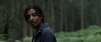 Movie still from “In the Earth” (2021), directed by Ben Wheatley – A man standing in the middle of a forest; Close Up shot, Low angle