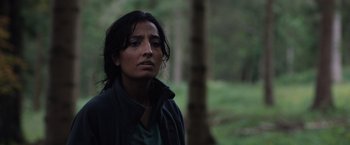 Movie still from “In the Earth” (2021), directed by Ben Wheatley – A woman standing in the middle of a forest; Close Up shot, Over the shoulder angle