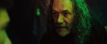 Movie still from “In the Earth” (2021), directed by Ben Wheatley – A person with long hair and a beard; Close Up shot, Low angle