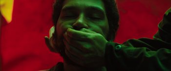 Movie still from “In the Earth” (2021), directed by Ben Wheatley – A man with his hands over his mouth; Extreme Close Up shot, Overhead angle