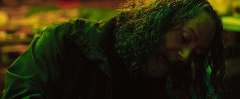 Movie still from “In the Earth” (2021), directed by Ben Wheatley – A man with long hair and a green jacket; Close Up shot, Low angle