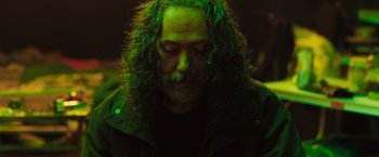 Movie still from “In the Earth” (2021), directed by Ben Wheatley – A man with long hair and a goatee is looking down; Close Up shot, Low angle