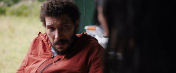 Movie still from “In the Earth” (2021), directed by Ben Wheatley – A person wearing a red jacket; Close Up shot, Over the shoulder angle