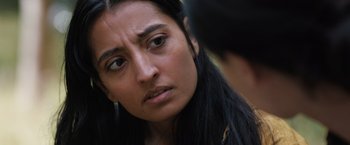 Movie still from “In the Earth” (2021), directed by Ben Wheatley – A person with long black hair; Close Up shot, Over the shoulder angle