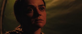 Movie still from “In the Earth” (2021), directed by Ben Wheatley – A person looking at the camera; Close Up shot, Low angle