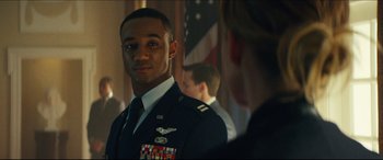 Movie still from “Independence Day: Resurgence” (2016), directed by Roland Emmerich – A man in a military uniform standing in front of an american flag; Close Up shot, Over the shoulder angle