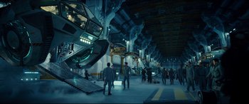 Movie still from “Independence Day: Resurgence” (2016), directed by Roland Emmerich – People are standing in an industrial area with a lot of machinery; Extreme Wide shot, High angle