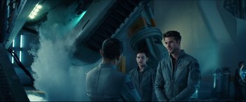 Movie still from “Independence Day: Resurgence” (2016), directed by Roland Emmerich – A group of men standing next to each other in a room; Medium shot, Low angle