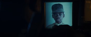 Movie still from “Independence Day: Resurgence” (2016), directed by Roland Emmerich – A portrait of a young boy with a hat on his head; Extreme Close Up shot, Over the shoulder angle