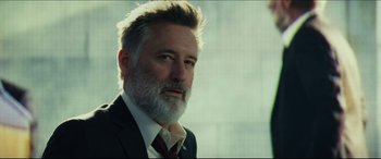 Movie still from “Independence Day: Resurgence” (2016), directed by Roland Emmerich – A person wearing a suit and tie; Close Up shot, Low angle