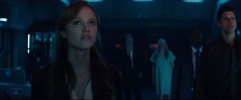 Movie still from “Independence Day: Resurgence” (2016), directed by Roland Emmerich – A woman standing next to two men in a dark room; Medium shot, Low angle