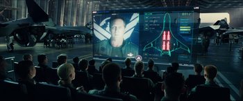 Movie still from “Independence Day: Resurgence” (2016), directed by Roland Emmerich – A group of people sitting in front of a large screen; Medium shot, Over the shoulder angle