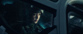 Movie still from “Independence Day: Resurgence” (2016), directed by Roland Emmerich – A woman wearing a helmet is looking out of a car window; Close Up shot, Low angle