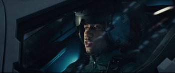 Movie still from “Independence Day: Resurgence” (2016), directed by Roland Emmerich – A person wearing a helmet in a car; Close Up shot, Over the shoulder angle
