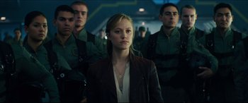 Movie still from “Independence Day: Resurgence” (2016), directed by Roland Emmerich – A woman standing in front of a group of soldiers; Medium shot, Over the shoulder angle