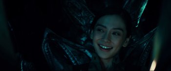 Movie still from “Independence Day: Resurgence” (2016), directed by Roland Emmerich – A woman smiling while laying down in a dark room; Close Up shot, Over the shoulder angle