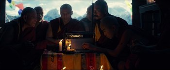 Movie still from “Independence Day: Resurgence” (2016), directed by Roland Emmerich – A group of monks sitting around a table with a computer; Medium shot, Low angle