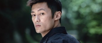 Movie still from “Infernal Affairs” (2002), directed by Alan Mak – A person wearing a black shirt; Close Up shot, Low angle