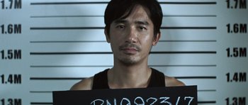 Movie still from “Infernal Affairs” (2002), directed by Alan Mak – A person with a mug on his chest; Close Up shot, High angle