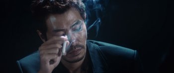 Movie still from “Infernal Affairs” (2002), directed by Alan Mak – A person smoking a cigarette; Close Up shot, Low angle