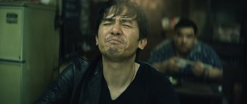 Movie still from “Infernal Affairs” (2002), directed by Alan Mak – A person with his eyes closed; Close Up shot, Low angle