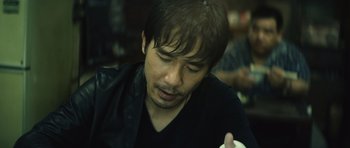 Movie still from “Infernal Affairs” (2002), directed by Alan Mak – A person holding something in his hand; Close Up shot, High angle