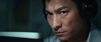 Movie still from “Infernal Affairs” (2002), directed by Alan Mak – A person wearing headphones; Close Up shot, Low angle