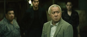 Movie still from “Infernal Affairs” (2002), directed by Alan Mak – A man in a gray suit and a man in a black shirt; Medium shot, Over the shoulder angle