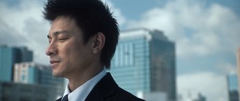 Movie still from “Infernal Affairs” (2002), directed by Alan Mak – A person wearing a suit and tie; Close Up shot, Low angle