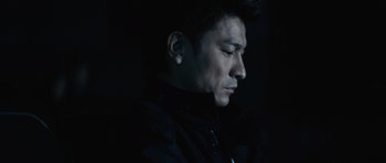 Movie still from “Infernal Affairs” (2002), directed by Alan Mak – A person wearing a black jacket; Close Up shot, Low angle