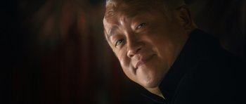 Movie still from “Infernal Affairs” (2002), directed by Alan Mak – An older man smiling with his eyes wide open; Extreme Close Up shot, Low angle