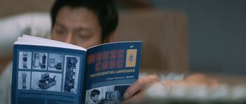 Movie still from “Infernal Affairs” (2002), directed by Alan Mak – A man reading a book about morse code; Extreme Close Up shot, High angle