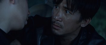 Movie still from “Infernal Affairs” (2002), directed by Alan Mak – A person in a car looking at the camera; Close Up shot, High angle